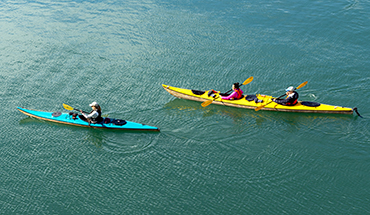 Kayakers paddle the calm waters of China Poot in Kachemak Bay, Homer, Alaska